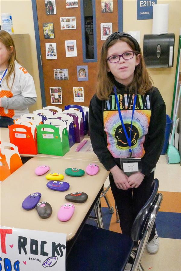 girl and painted rocks on a desk